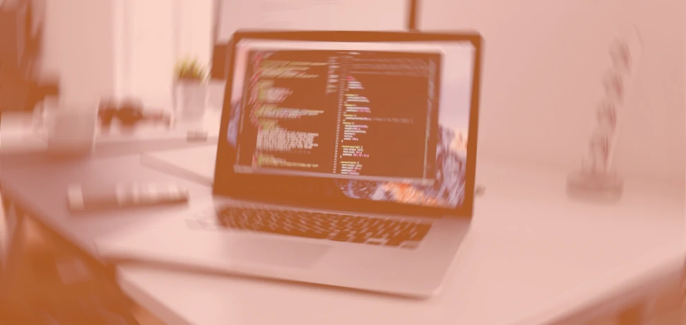 website-design-and-development-uk-company A laptop on a desk showing website development code in a web design agency office