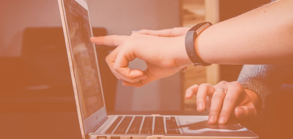 Two website developers performing maintenance and security updates at a laptop